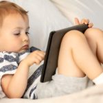 Toddler screen time with tablet in his lap