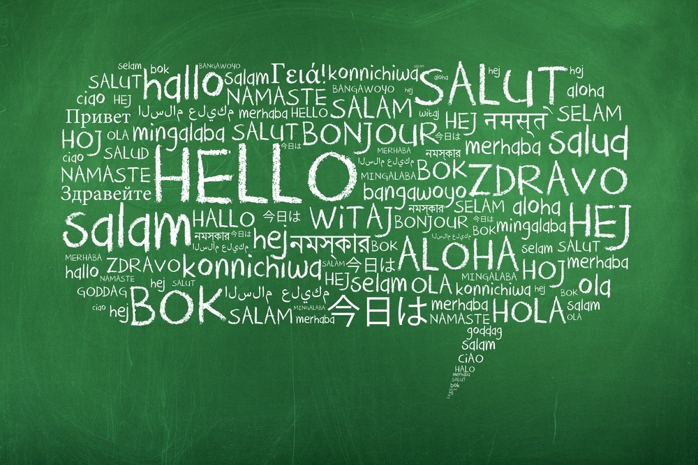 A green chalkboard features "hello" written in various languages, including English, French, Spanish, and more, arranged in a speech bubble shape.