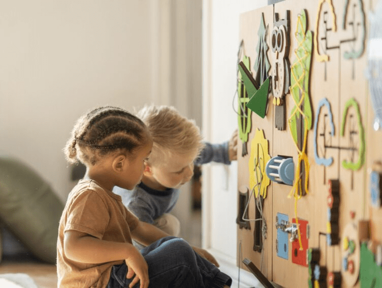 Children playing with a multisensory toy wall.