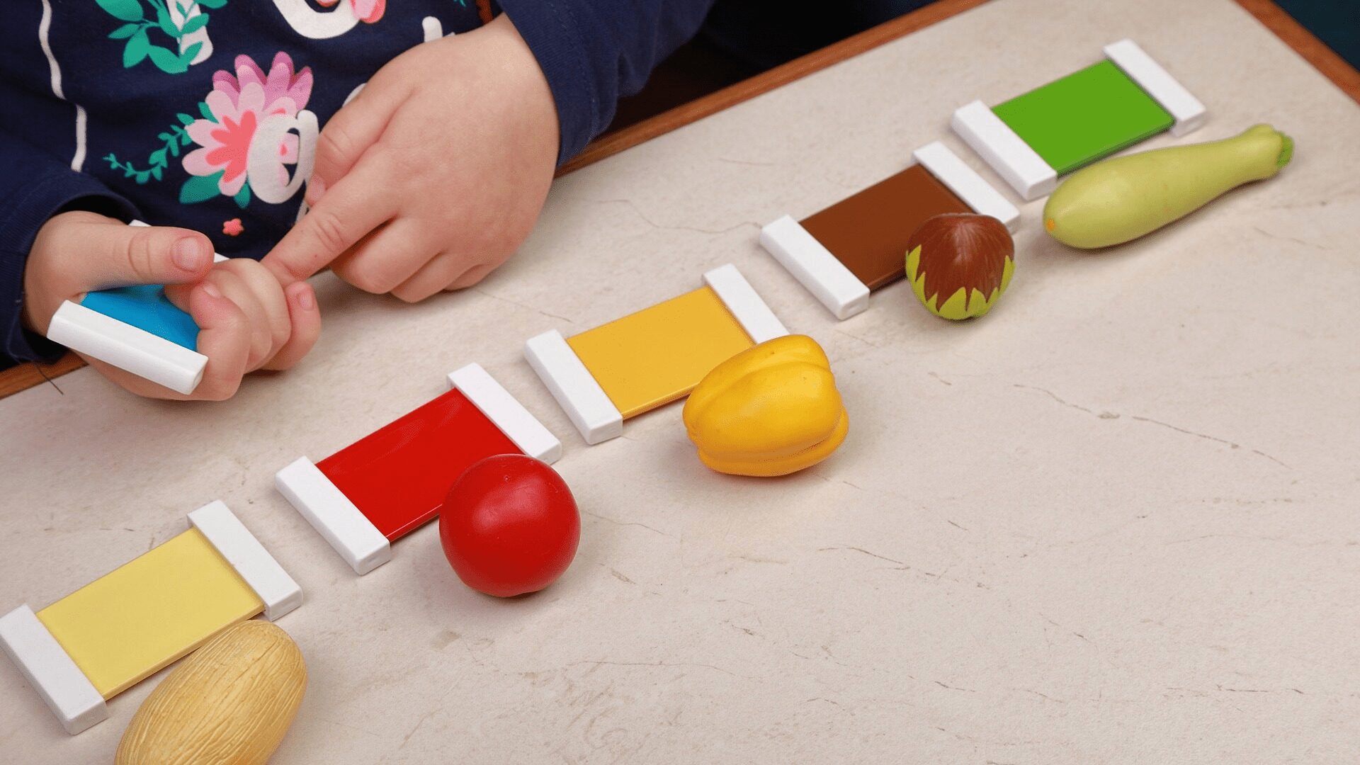 A child playing with colour-identification toys.